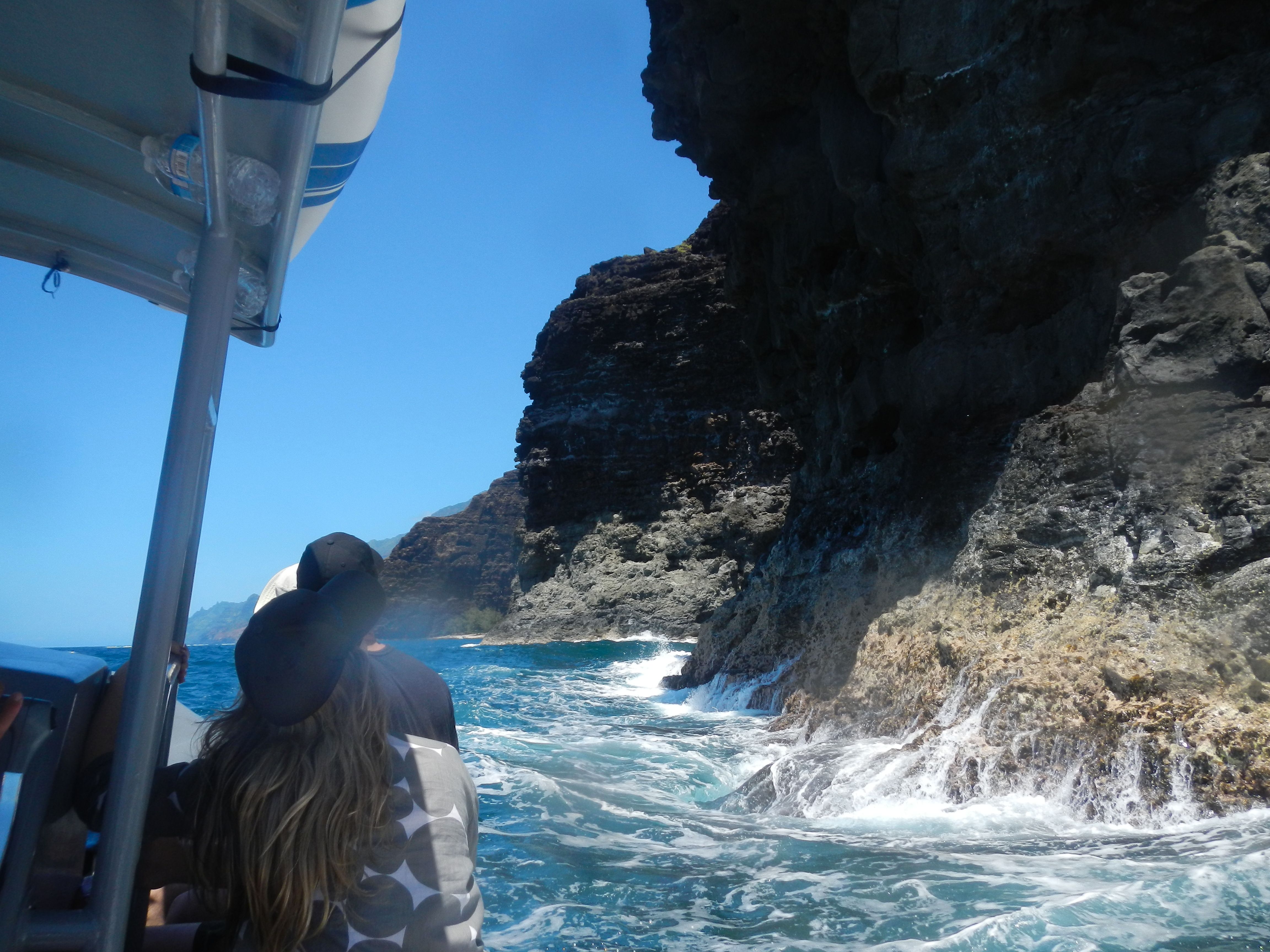 Guests looking toward the Na Pali sea cliffs from a boat on the water